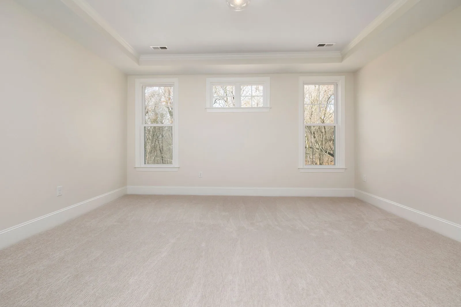An empty room with new ivory carpet laid wall to wall