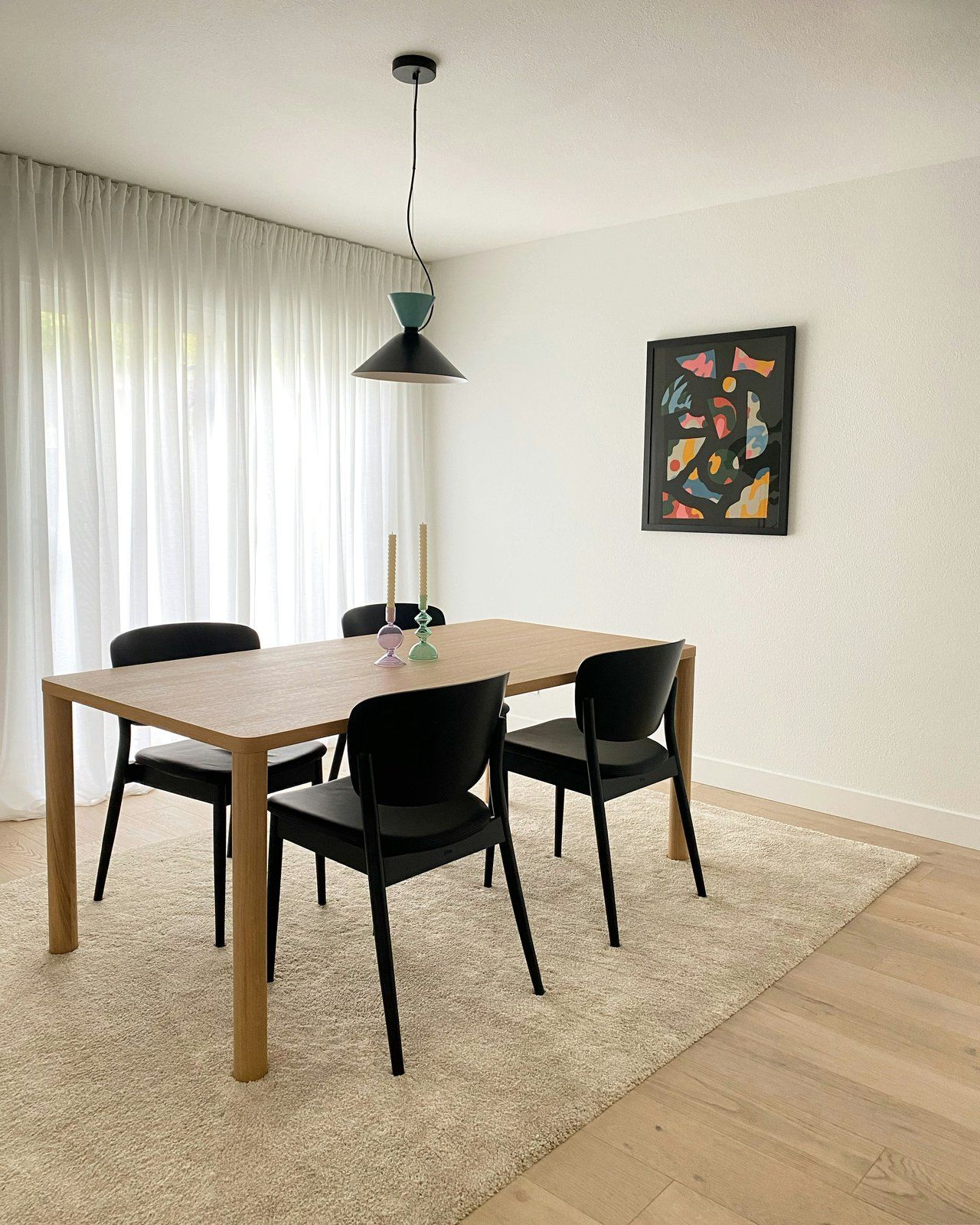 A plain rug under a dining table, wide enough for the chairs to stay on it